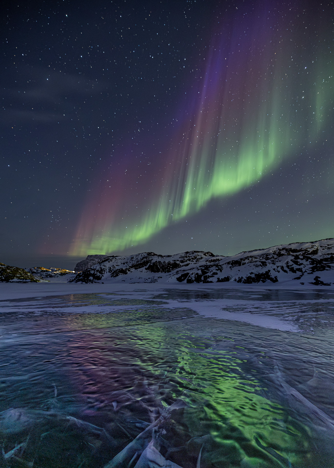 Aurora mit Reflexion auf einem zugefrorenen See